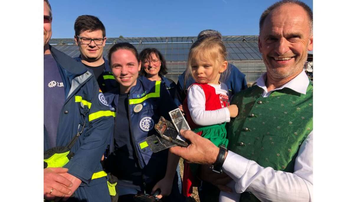 Gärtner Jürgen (rechts) freut sich, dass die Ehrenamtlichen vom THW sein Handy mit über 900 Kontakten auf der SIM-Karte geborgen haben.