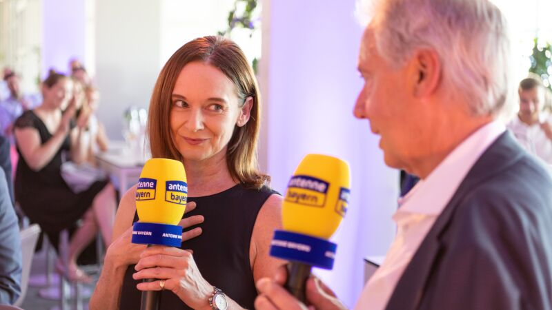 Sigrid Leininger, erste Mitarbeiterin von ANTENNE BAYERN, hält Karlheinz Hörhammer zum letzten Mal die Tür auf