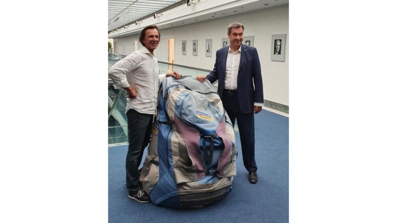 Ministerpräsident Markus Söder freut sich über den XXL-Bayern-Rucksack, überreicht von ANTENNE BAYERN-Moderator Wolfgang Leikernoser